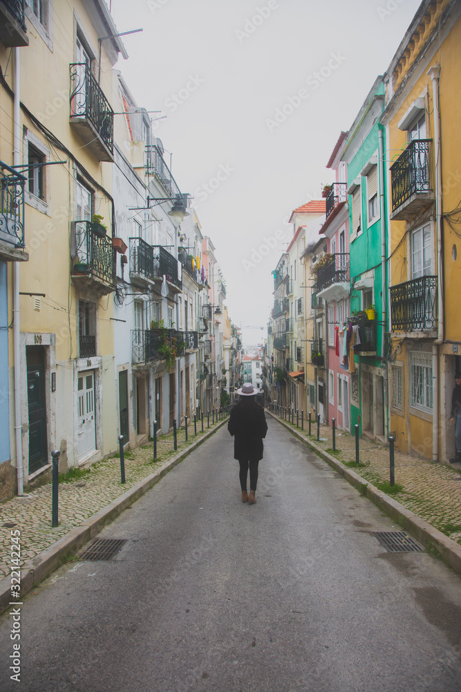 Mujer caminando por las calles de Portugal un día nublado