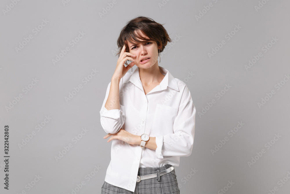 Preoccupied upset young business woman in white shirt posing isolated on grey wall background studio portrait. Achievement career wealth business concept. Mock up copy space. Putting hand on head. Preoccupied upset young business woman in white shirt posing isolated on grey wall background studio portrait. Achievement career wealth business concept. Mock up copy space. Putting hand on head.