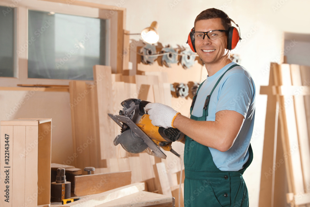Professional carpenter with circular saw in workshop Professional carpenter with circular saw in workshop