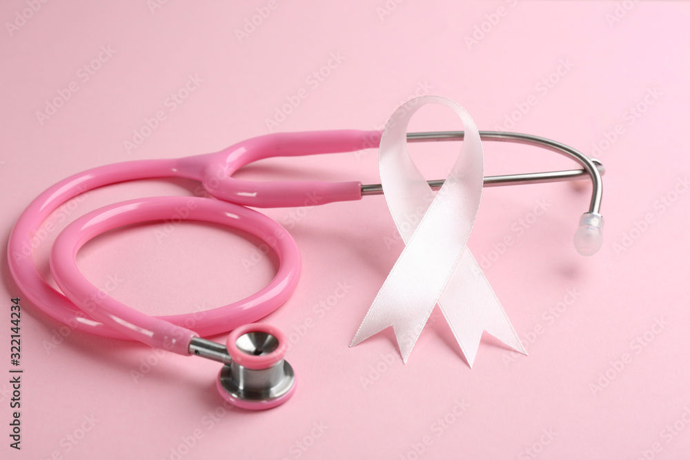 Pink ribbon and stethoscope on color background, closeup. Breast cancer concept Pink ribbon and stethoscope on color background, closeup. Breast cancer concept