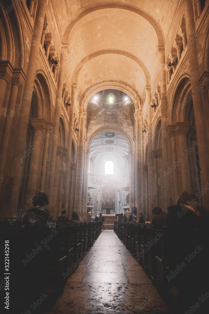 Gente rezando en una iglesia antigua con grandes columnas y cúpulas