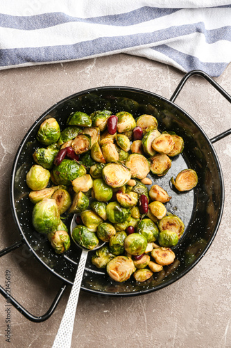 Delicious roasted brussels sprouts with red beans and peanuts on grey marble table, top view