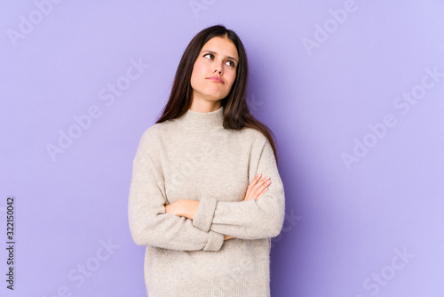 Young caucasian woman isolated on purple background tired of a repetitive task.
