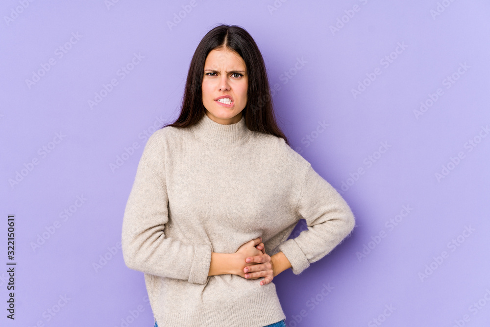 Young caucasian woman isolated on purple background having a liver pain, stomach ache. Young caucasian woman isolated on purple background having a liver pain, stomach ache.