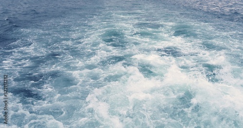 Boat trace water foam trace behind the ship.
