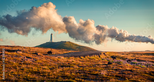 Panoramic summer view of Reykjanes Lighthouse with steam from a Gunnuhver Hot Springs. Exotic evening scene of Iceland, Europe. Traveling concept background.. photo