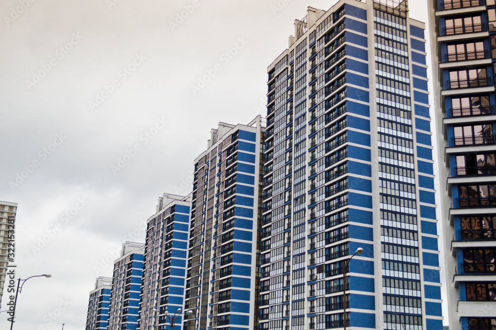 Fototapeta premium New modern tall blue glass multi-storey comfortable urban monolithic frame houses buildings skyscrapers new buildings in the big city of the megalopolis