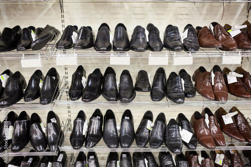 Man shoes store with classic male footwear on shelves
