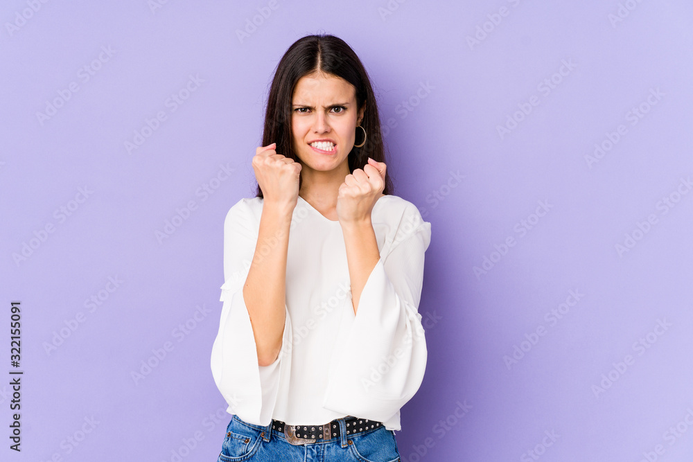 Young caucasian woman isolated on purple background upset screaming with tense hands. Young caucasian woman isolated on purple background upset screaming with tense hands.