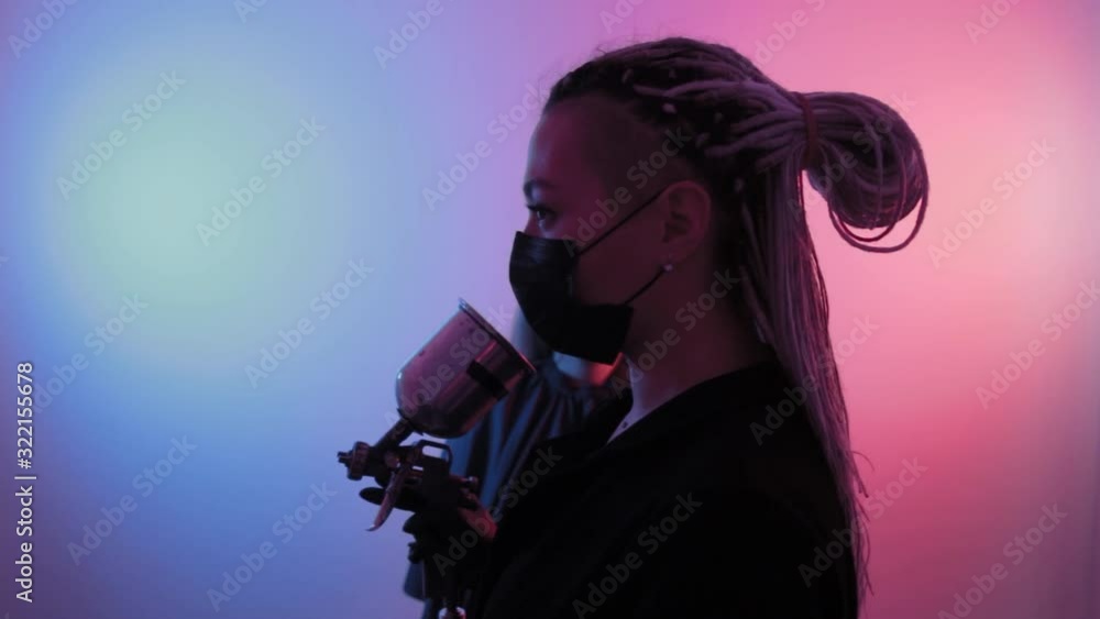 Young woman with a spray gun does makeup to a client. Young woman with a spray gun does makeup to a client.