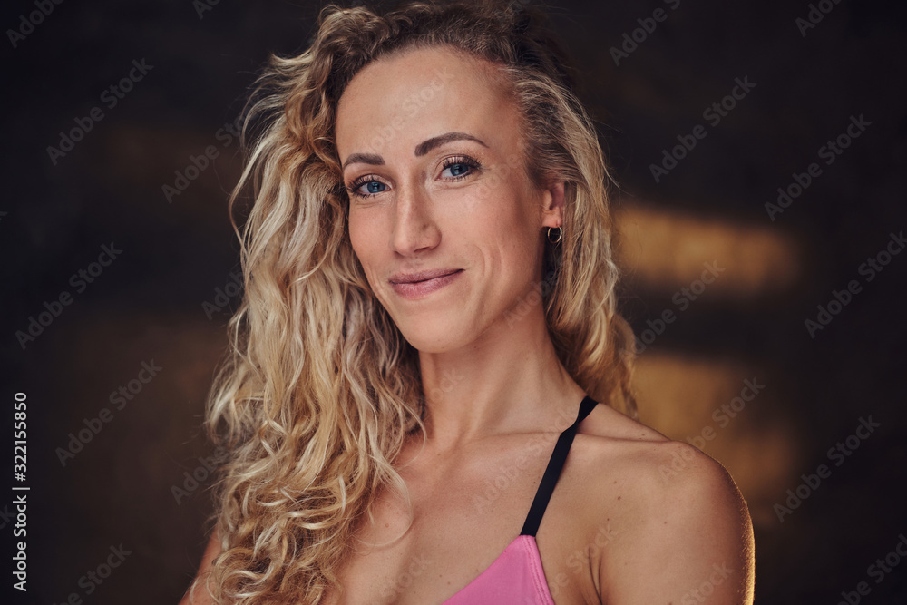 Attractive blond woman in sporty pink top is posing for photographer. Attractive blond woman in sporty pink top is posing for photographer.