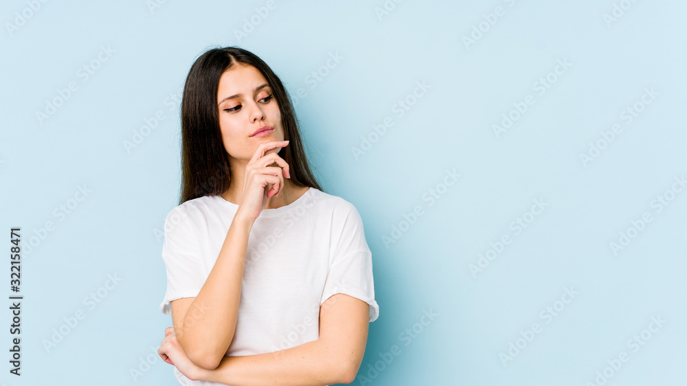 Young caucasian woman isolated on blue background looking sideways with doubtful and skeptical expression. Young caucasian woman isolated on blue background looking sideways with doubtful and skeptical expression.