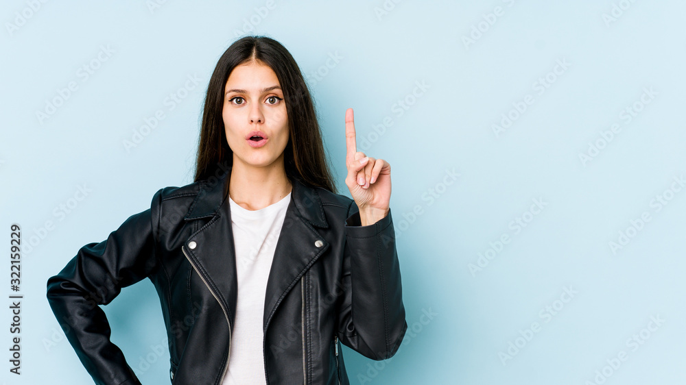 Young caucasian woman isolated on blue background pointing upside with opened mouth. Young caucasian woman isolated on blue background pointing upside with opened mouth.