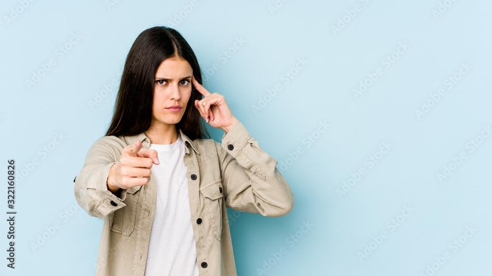 Young caucasian woman isolated on blue background pointing temple with finger, thinking, focused on a task. Young caucasian woman isolated on blue background pointing temple with finger, thinking, focused on a task.
