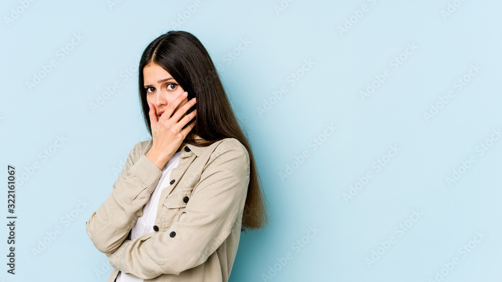 Obraz premium Young caucasian woman isolated on blue background scared and afraid.