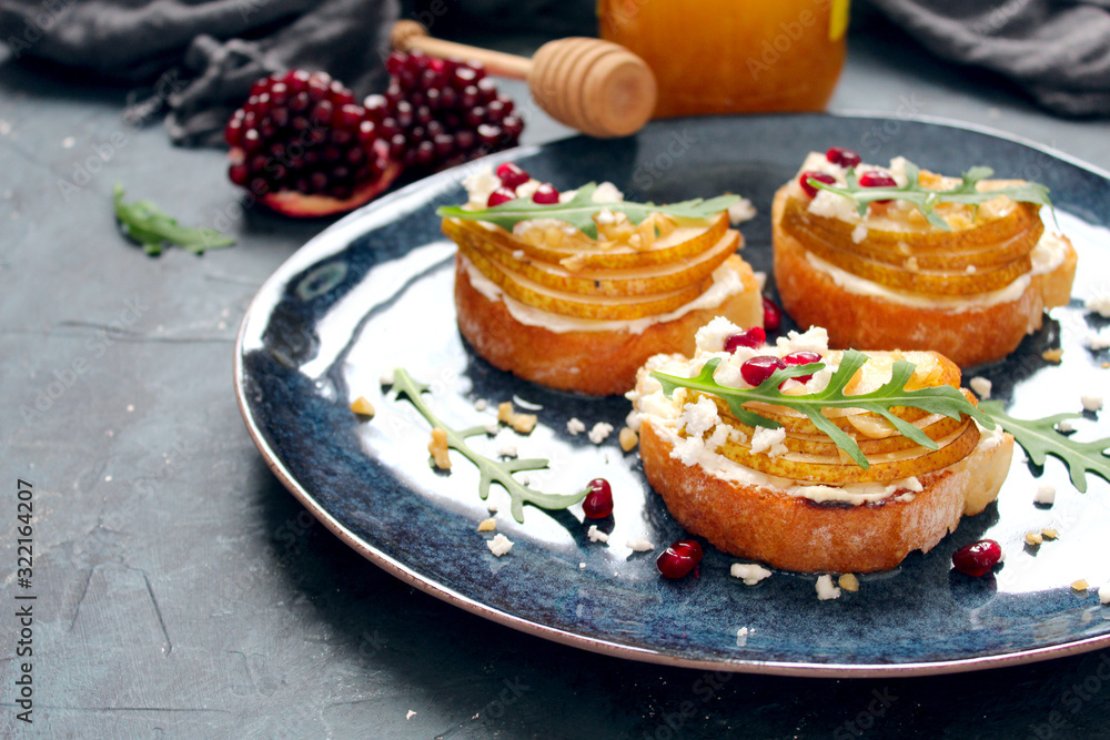 Crostini with pear, feta cheese, honey, nuts and pomegranate. Top view with copy space.