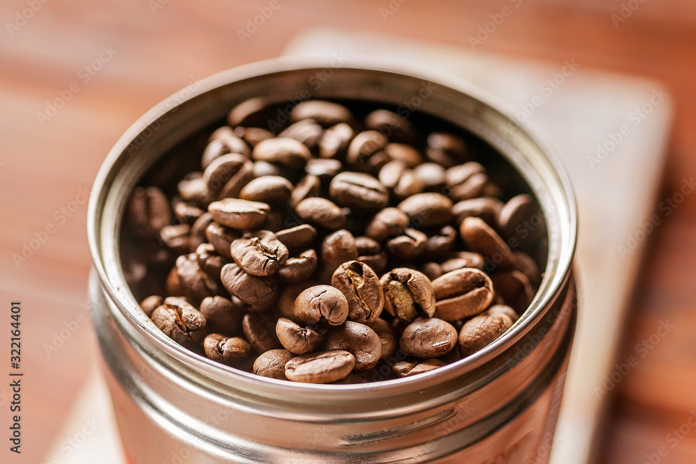 Fototapeta premium Coffee beans in a can. Roasted aromatic coffee close-up. Sunlight on background