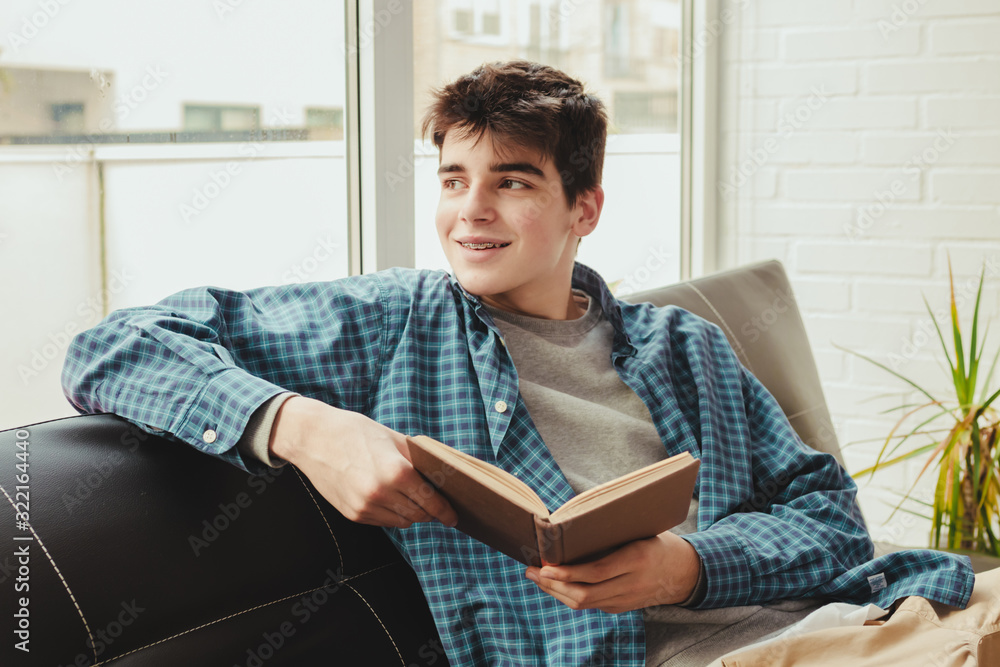 young teenage boy reading or studying at home