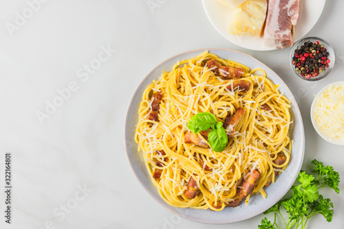 Carbonara pasta, spaghetti with bacon, egg, hard parmesan cheese and basil in a plate. Traditional italian cuisine