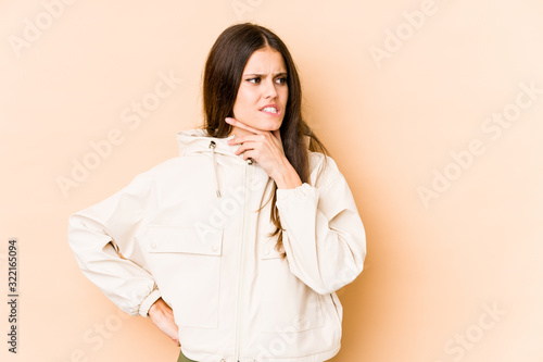 Young caucasian woman isolated on beige background touching back of head  thinking and making a choice.