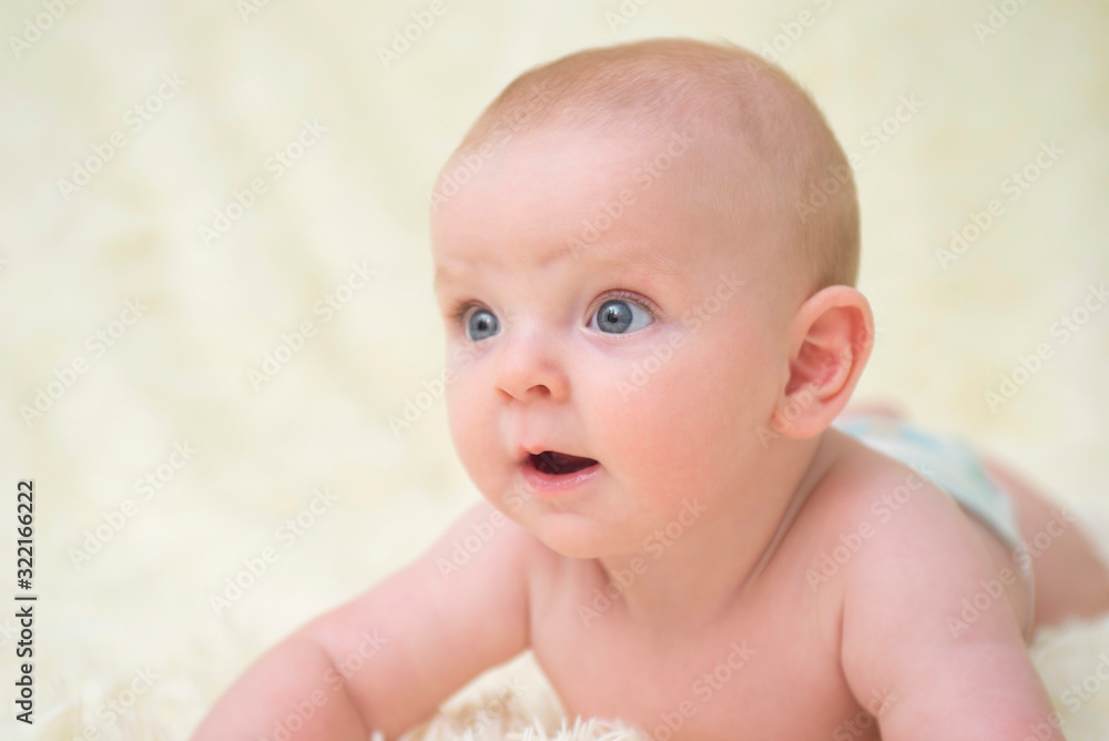 Funny little baby lying down on a blanket . Newborn child relaxing in bed Funny little baby lying down on a blanket . Newborn child relaxing in bed