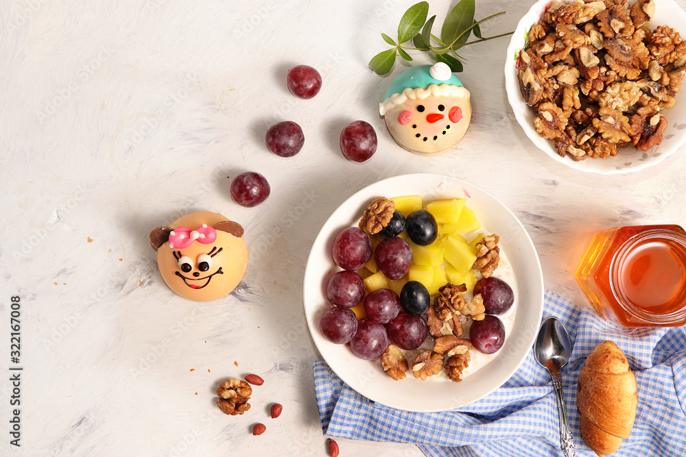 Healthy breakfast, fun food for children. The concept of healthy and natural food. Oatmeal with granola or granola, grapes, nuts and croissants, top view, selective focus. Healthy breakfast, fun food for children. The concept of healthy and natural food. Oatmeal with granola or granola, grapes, nuts and croissants, top view, selective focus.