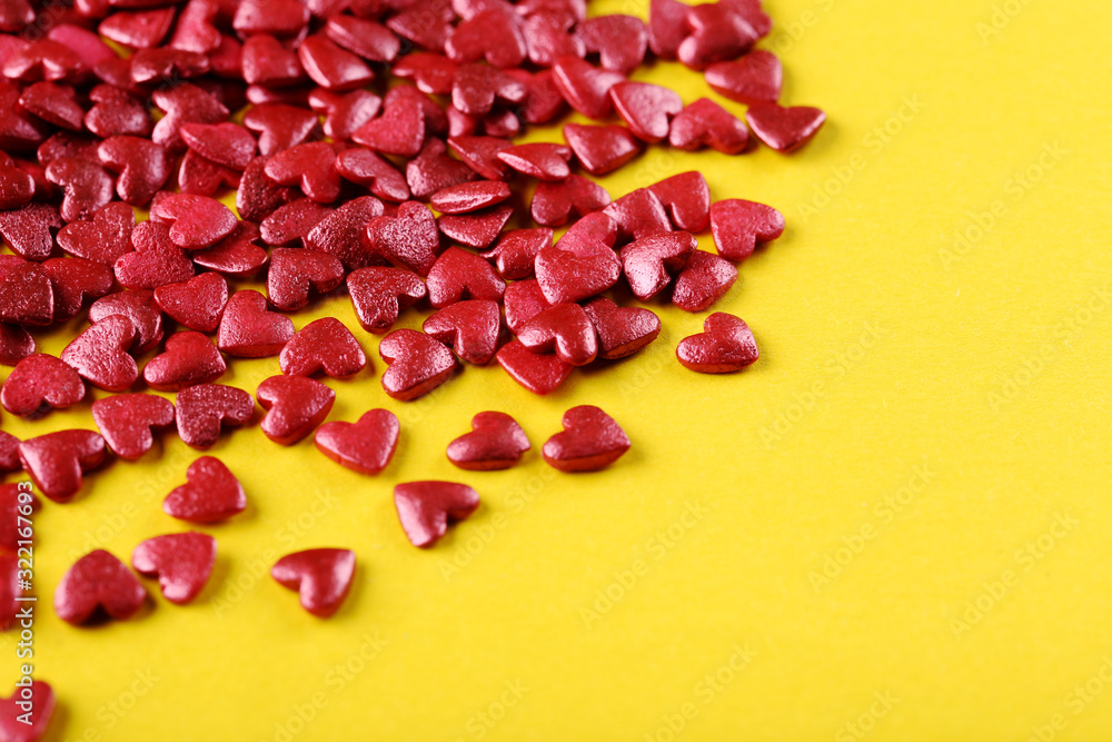 Heart shaped sprinkles on yellow background Heart shaped sprinkles on yellow background