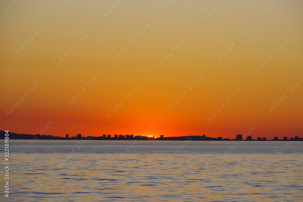 A romantic sunset against the background of the orange sky and fantastic glimpses of the reflecting sun in the bluish-gray water. An evening that is impossible to forget.