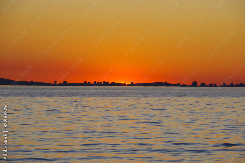 A romantic sunset against the background of the orange sky and fantastic glimpses of the reflecting sun in the bluish-gray water. An evening that is impossible to forget.