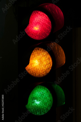 Bilde på lerret Traffic light stoplight with red, yellow, and green lights all glowing against a