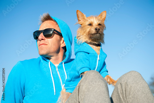 Quadro em tela Man and his doggy best friend wearing matching blue hoody sweatshirts outdoors u
