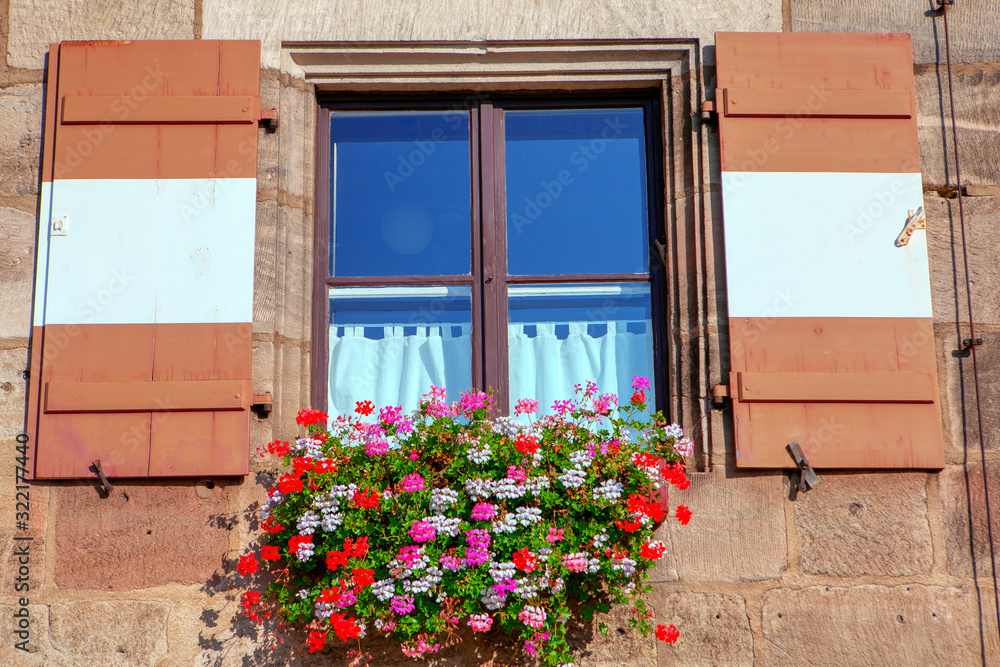 window shutters in retro style with flower beds 