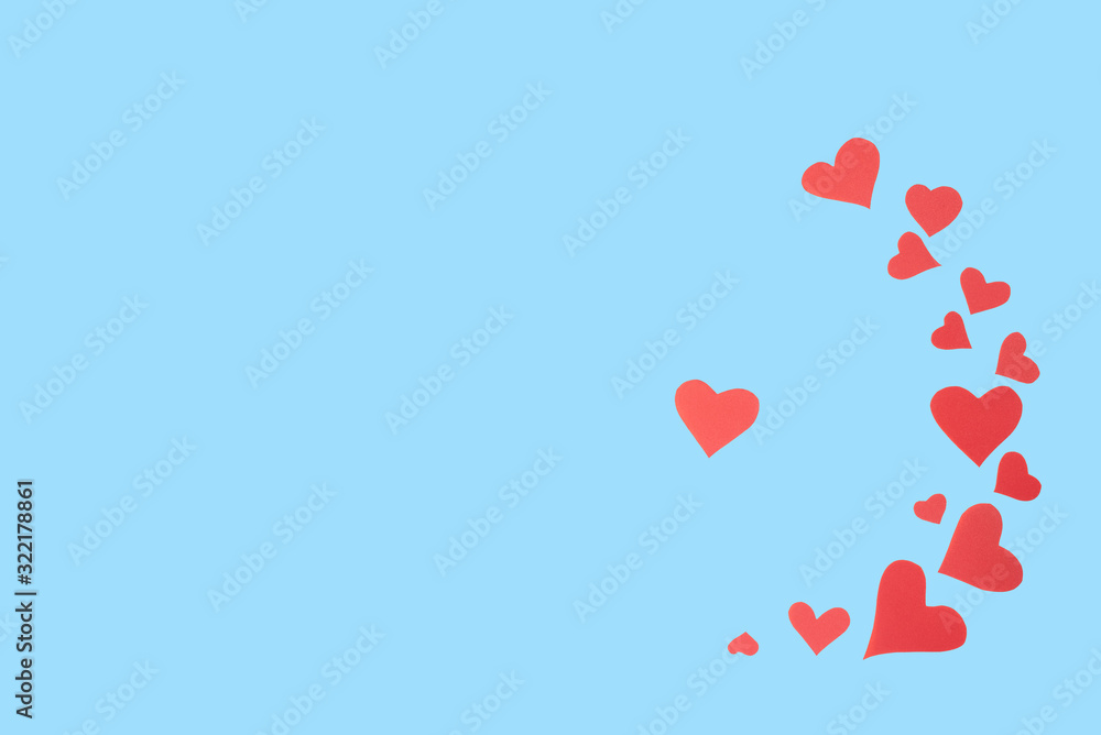 Red hearts on a blue, turquoise background on the right side of the image. Valentine's day concept. Valentine place for text in the middle of the frame.