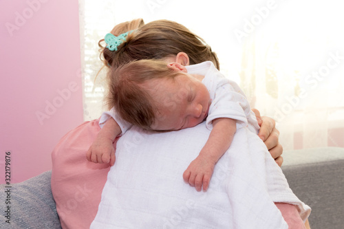Tablou pe pânză Happy baby girl sleeping on mother shoulder