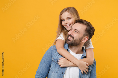 Cheerful bearded man in casual clothes have fun with cute child baby girl. Father little kid daughter isolated on yellow background in studio. Love family day parenthood childhood concept. Hugging.