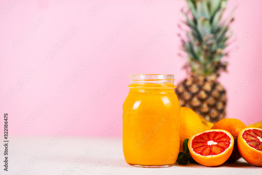 Close up is a jar of fresh yellow smoothie made from natural fruit on a pink background. Close up is a jar of fresh yellow smoothie made from natural fruit on a pink background.