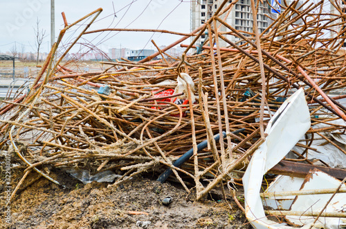 A mess at a construction site with scattered building materials and rubbish with dirt, poor safety precautions, unsanitary conditions and environmental pollution at an industrial construction site