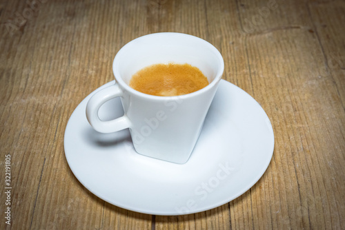 close up white cup of espresso on vintage wooden table