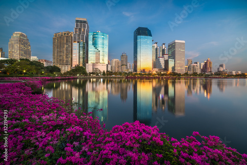 Lake with Purple Flowers in City Park under Skyscrapers at Twilight. Benjakiti Park in Bangkok, Thailand © kaycco