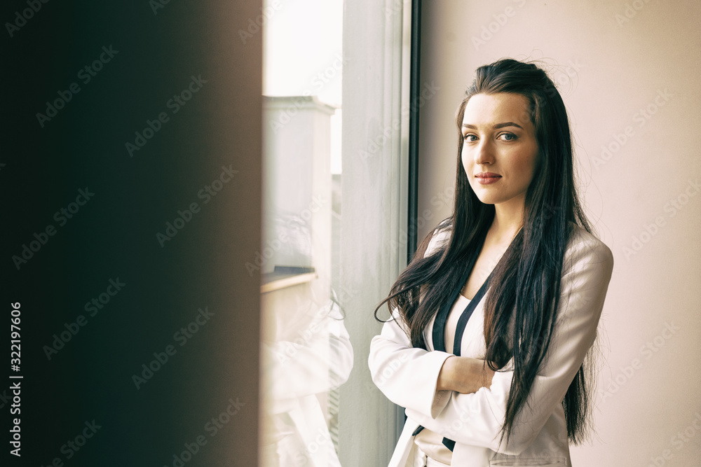 Businesswoman in white clothes by the window