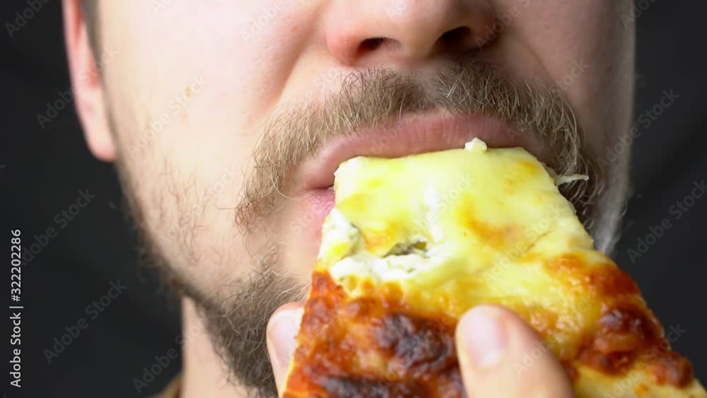A young man eats pizza slow motion super close up A young man eats pizza slow motion super close up