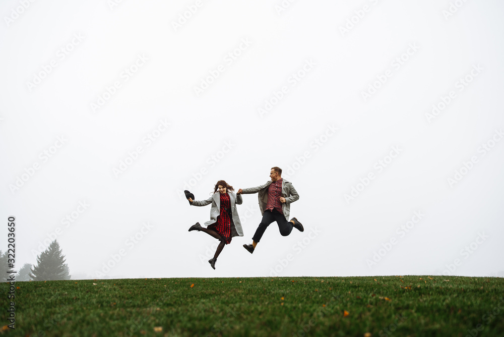 Loving couple have fun together, they jumping on the grass Loving couple have fun together, they jumping on the grass