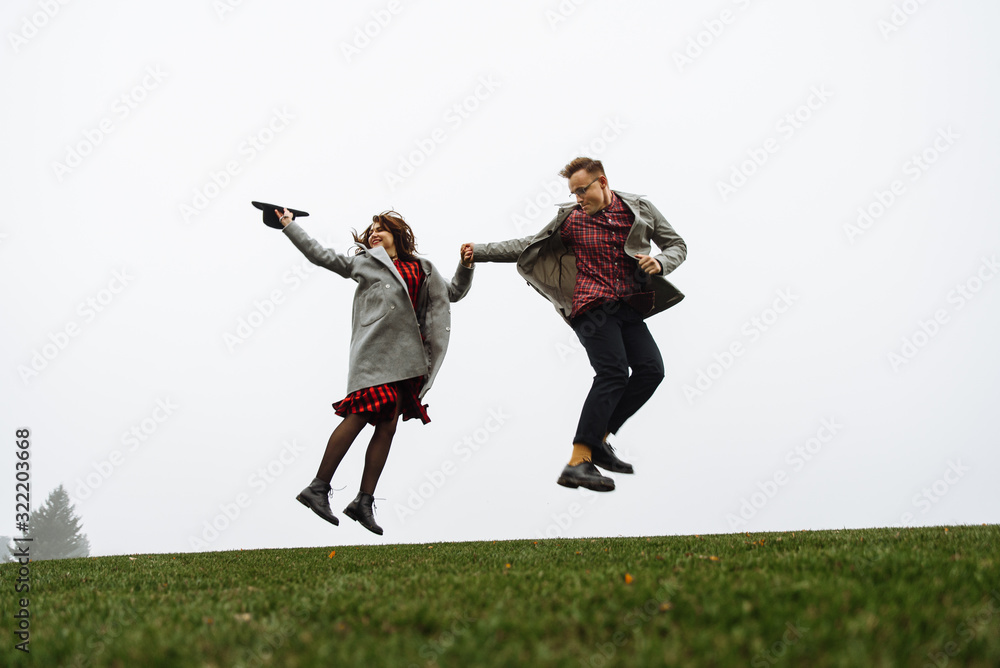 Loving couple have fun together, they jumping on the grass Loving couple have fun together, they jumping on the grass