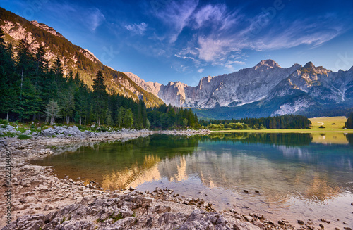 Amazing view on Lago di Fusine Inferiore at sunrise. Splendid morning scene of Julian Alps  Province of Udine  Italy  Europe. Beautiful forests are reflected in the quiet lake. Dolomites mountains.