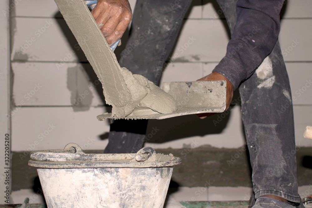 Close-up of construction workers using plastering equipment for plastering the walls of the house to build the house. Close-up of construction workers using plastering equipment for plastering the walls of the house to build the house.