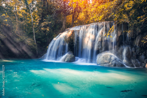 Fototapeta Naklejka Na Ścianę i Meble -  Waterfall, green forest in Erawan National Park, Thailand. Landscape with water flow, river, stream and rock at outdoor. Beautiful scenery of nature for tourist to tour, visit, relax in vacation.