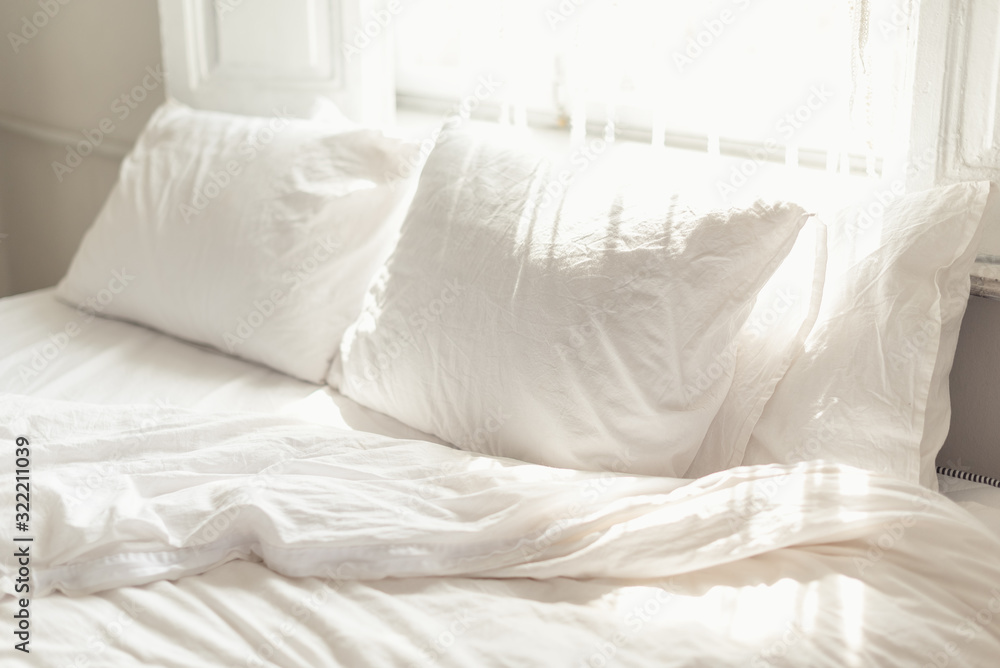 White pillow and bedclothes in bright bedroom