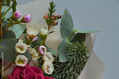 Detail closeup of romantic bridal or congratulatory bouquet, light gray background, selective focus photo