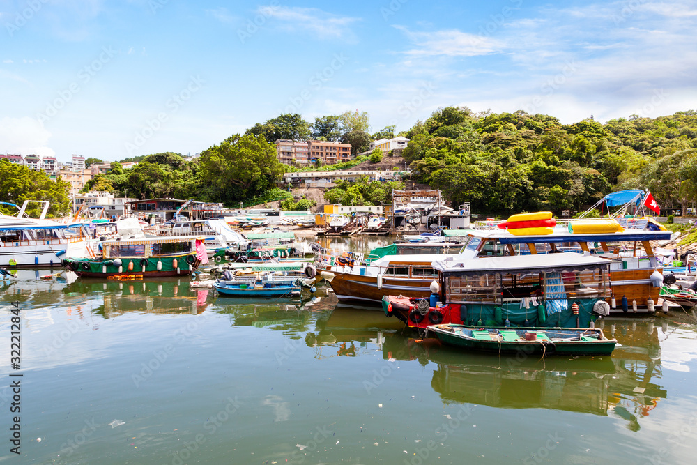 Fishing and tour boats dock at the busy harbor in Sai Kung, Hong Kong, a town famous for its quaint fishing villages and the floating seafood market