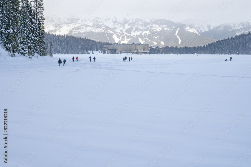 People ski, skate and hike on frozen Lake Louise in Banff National Park, Alberta, Canada